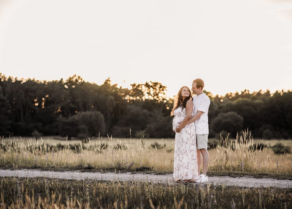 Werdende Eltern beim Babybauch-Shooting im Hainberg im goldenen Licht der untergehenden Sonne.