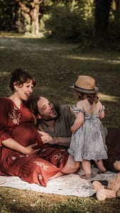 Familie mit werdender Mama und kleinem Kind auf einer Picknickdecke im Fürther Stadtpark beim Babybauchshooting