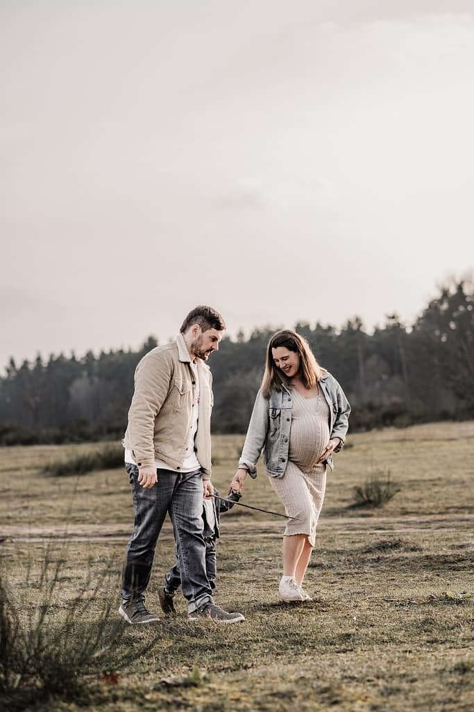 Familie mit KLeinkind und werdender Mama bei einem Spaziergang in der Natur beim Familien- und Babybauch- und Familien-Fotoshooting draußen bei Fürth und Nürnberg