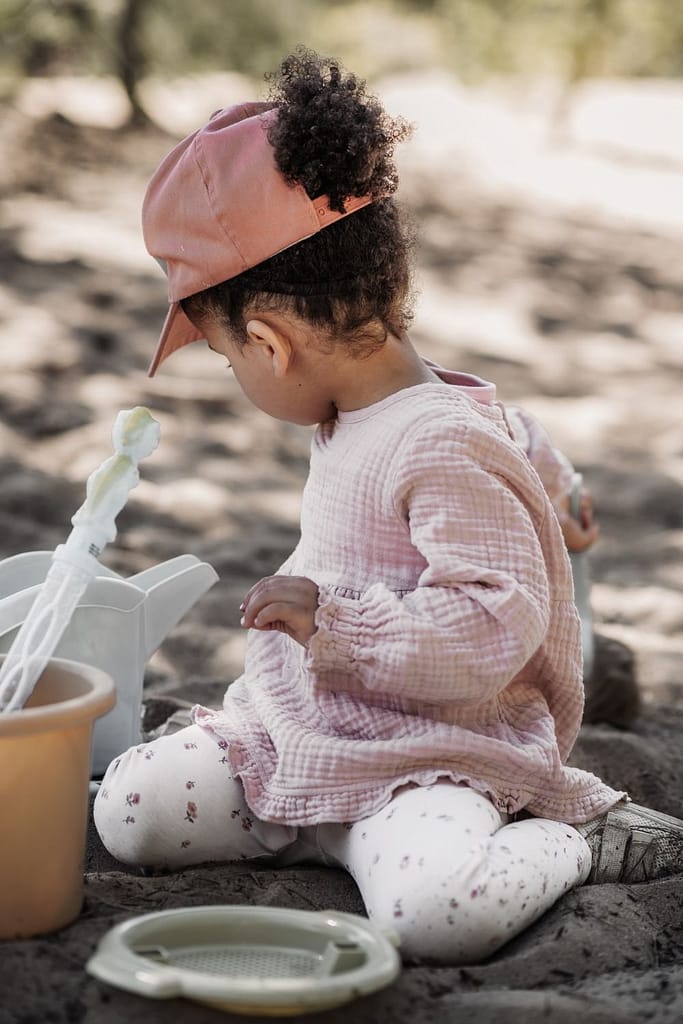 Kleines Kind mit Kappe im spielt im Sand am fränkischen Dünenweg