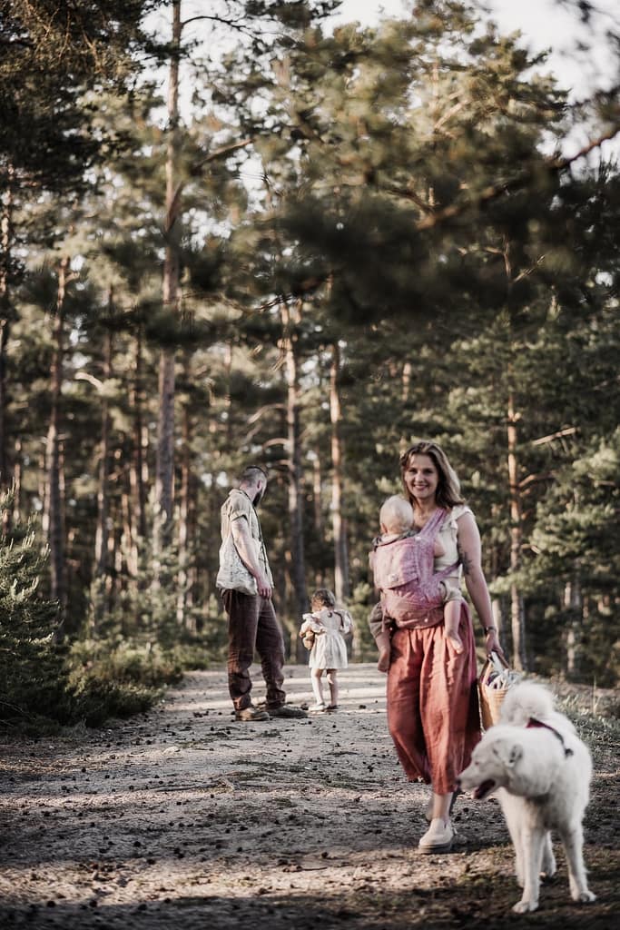 Familienshooting am fränkischen Dünenweg mit 2 kleinen Kindern und 2 Hunde. Die Familie läuft auf sandigem Weg im Kiefernwald.