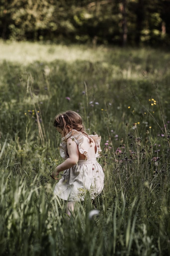 Kleinkind in Wildblumenwiese beim Familienshooting am fränkischen Dünenweg.