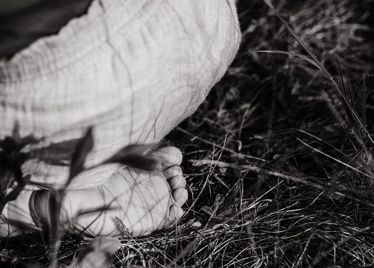 Ein kleiner Kinderfuß in der Nahaufnahme. Draußen in der Natur umgeben von Gras beim Familienshooting Nürnberg Fürth.
